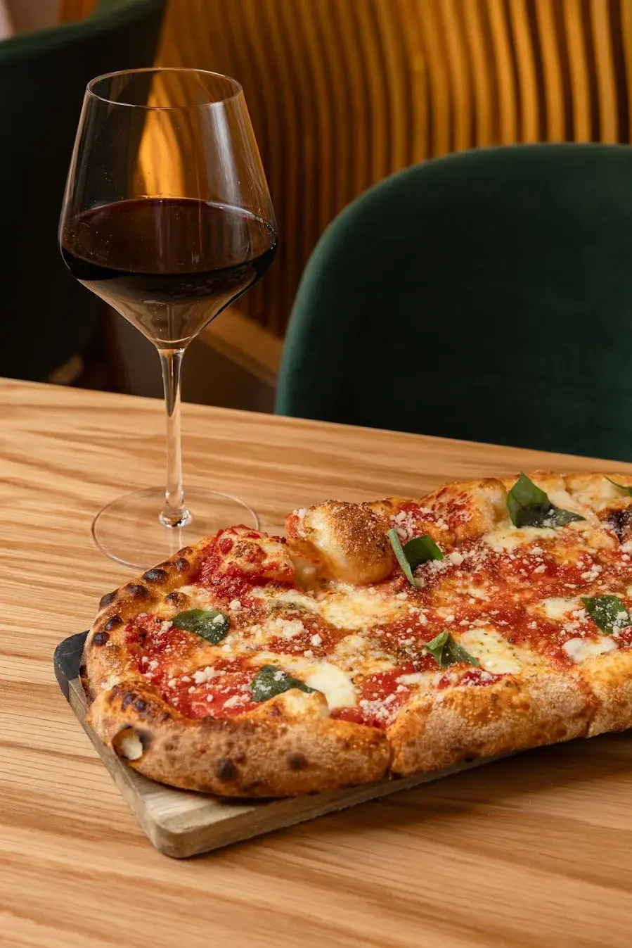 A long Roman-style Margherita pizza on a wooden paddle